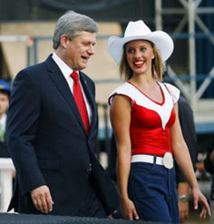 Canadian Prime Minister Stephen Harper is escorted off the stage by a dancer at the opening ceremonies for the World Skills Competition in Calgary, September 1, 2009. REUTERS/Todd Korol.