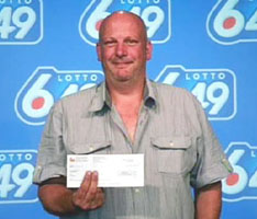 Barry Shell of Brampton, Ontario picks up his winning cheque at the Ontario Lottery and Gaming headquarters in Toronto, Monday, July 20, 2009. OLG authorities had already discovered he was wanted by police for theft. Immediately after posing with his $4,377,298 cheque, he was arrested by police. 